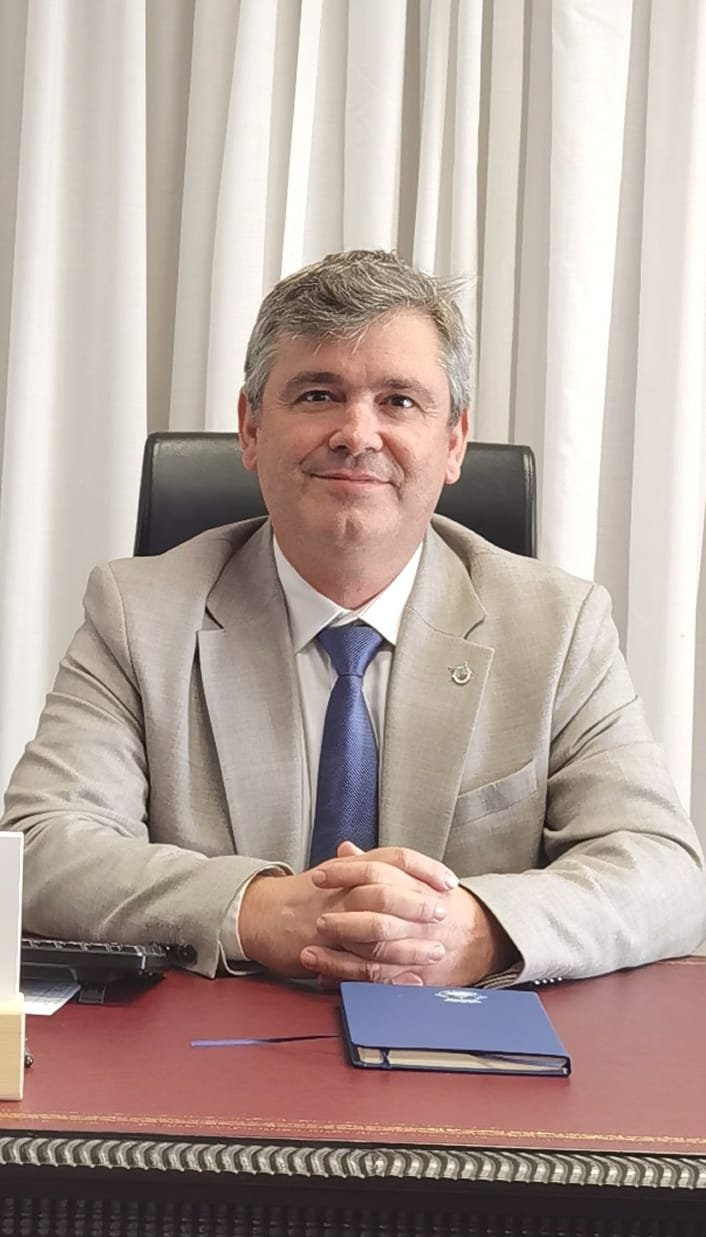 Retrato executivo em ambiente corporativo Homem de meia-idade em traje empresarial sentado a uma secretária